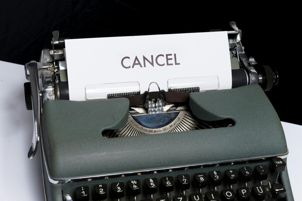 Máquina de escrever com a palavra CANCEL, simbolizando a cultura do cancelamento e o moralismo digital.