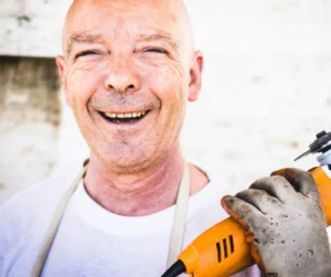 Funcionário sorridente com ferramenta, representando satisfação no trabalho e employer branding.